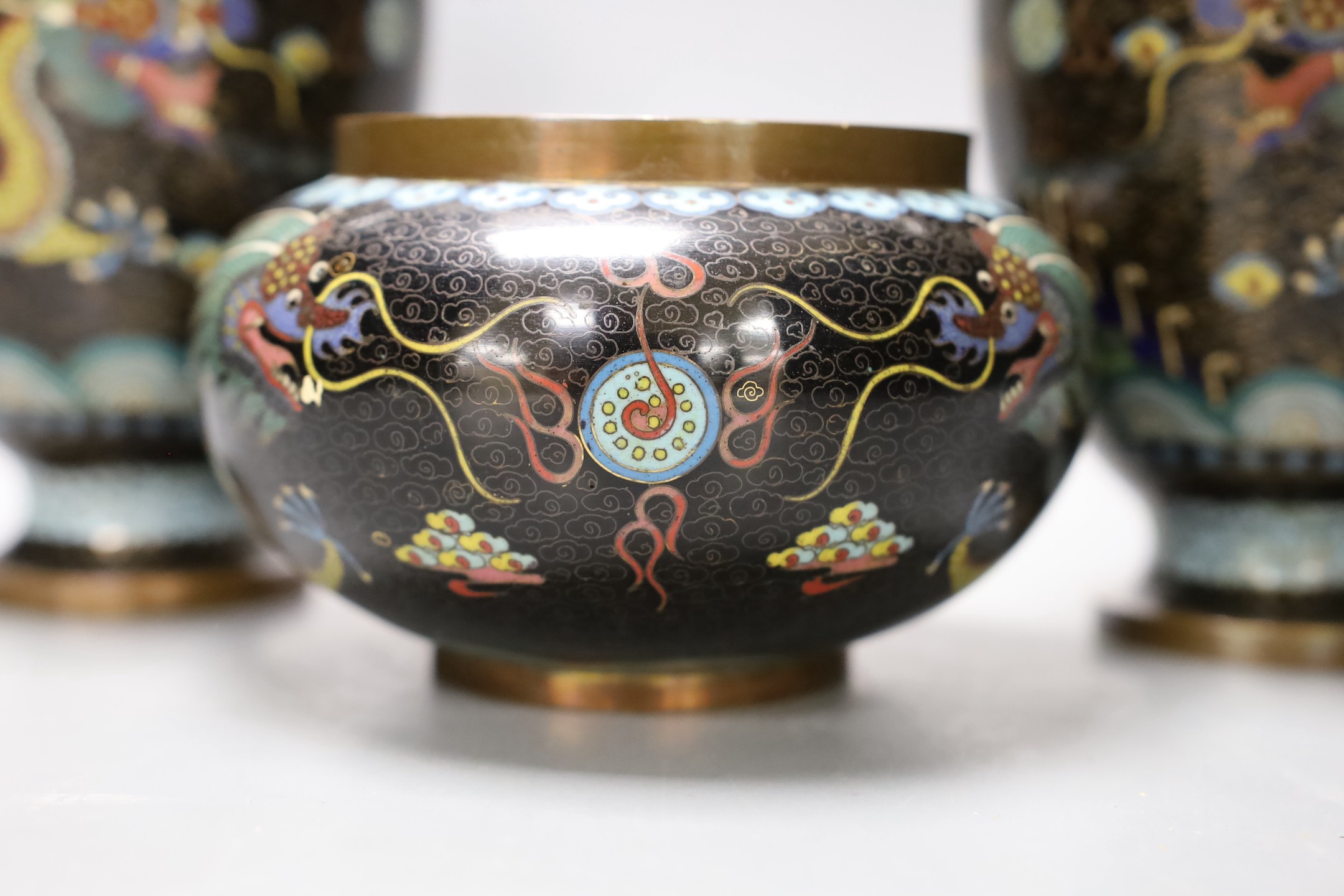 A pair of early 20th century Chinese cloisonne enamel 'dragon' vases and a matching bowl